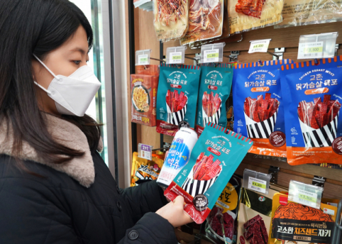 고객이 교촌치킨이 개발한 육포를 세븐일레븐에서 구매하고 있다./자료 제공=세븐일레븐