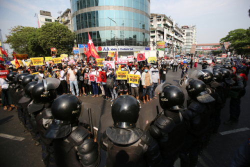 미얀마 최대 도시 양곤에서 19일(현지시간) 군부 쿠데타 규탄 시위대가 도열한 진압 경찰과 대치하고 있다. 지난 9일 쿠데타 규탄 시위 도중 경찰이 쏜 총에 머리를 맞아 중태에 빠졌던 20대 시위 참가자가 이날 숨진 것으로 알려지면서 시위가 한층 더 거세질 것으로 전망된다./AP연합뉴스