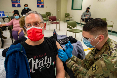 미국 매사추세츠주 이스트 보스턴의 한 신종 코로나바이러스 감염증(코로나19) 백신 접종소에 배치된 주 방위군 병사가 한 주민에게 백신을 접종하고 있다. /AFP연합뉴스