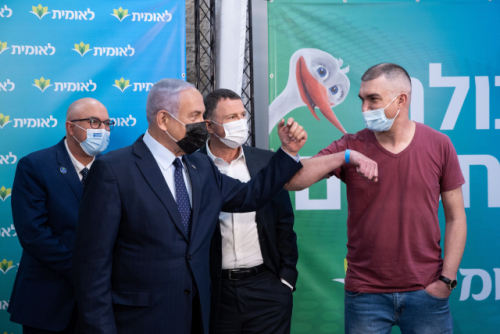 베냐민 네타냐후(왼쪽에서 두 번째) 이스라엘 총리가 16일(현지시간) 예루살렘의 한 코로나19 백신 접종소에서 400만 명째 접종자와 팔꿈치 인사를 나누고 있다./EPA연합뉴스