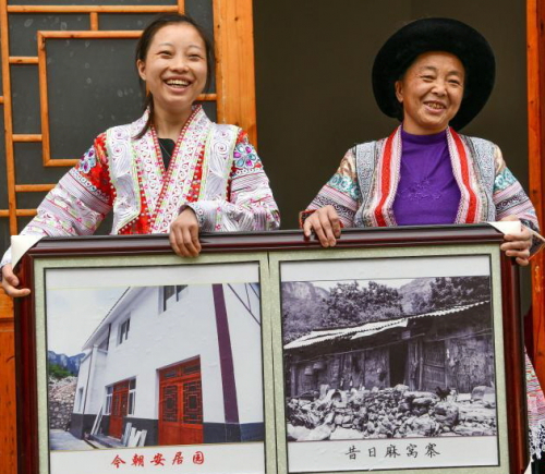 중국 남서부 구이저우성의 한 농촌 마을 주민이 자신의 집의 과거와 현재 사진을 들고 활짝 웃고 있다. 중국 정부는 이러한 농촌개량 사업을 중공의 성과로 내세우고 있다. /신화망