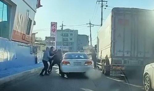지난 8일 경기 화성시 한 도로에서 용의자들이 피해자들을 차량에서 끌어내고 있다. /연합뉴스