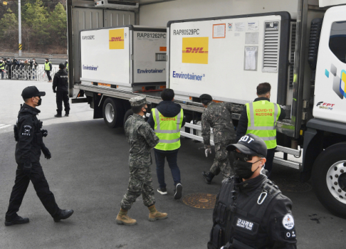 관계자들이 물류센터에 도착한 백신 수송 차량의 이상유무를 점검하고 있다./이천=사진공동취재단