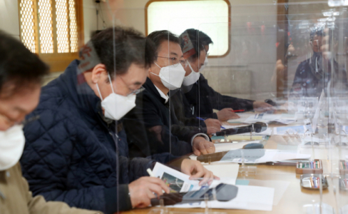 문재인 대통령이 25일 부산에서 열린 '동남권 메가시티 구축 전략 보고'에 참석, 가덕도 공항 후보지로 이동하며 선상에서 이병진 부산시장 권한대행으로부터 '가덕도 공항 건설 및 동남권 문화공동체 추진 전략' 보고를 받고 있다./연합뉴스