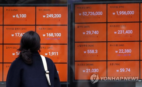 한 시민이 비트코인 가격이 급등한 2월 15일 서울 빗썸 강남센터에 위치한 암호화폐 시세 현황표를 바라보고 있다./연합뉴스