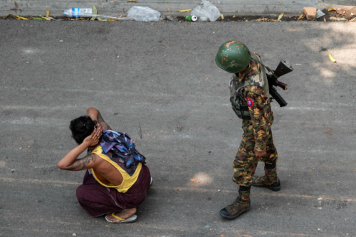 미얀마 제2의 도시 만달레이에서 3일(현지시간) 연행된 군부 쿠데타 규탄 시위 참가자 곁에 총을 멘 군인이 서 있다./AFP연합뉴스
