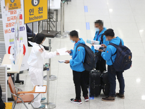 지난 4일 오전 인천국제공항 제1여객터미널에서 해외입국자들이 방역관계자의 안내를 받고 있다./연합뉴스