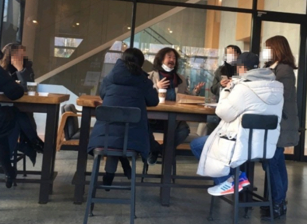 TBS ‘김어준의 뉴스공장’ 진행자 김어준씨가 지난 1월 19일 커피전문점에서 마스크를 턱에 걸치고 일행과 이야기하는 장면이 찍혔다./온라인 커뮤니티 캡처