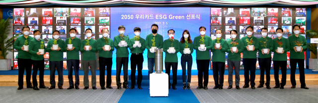 김정기(왼쪽 열번째) 우리카드 사장이 5일 서울 광화문 우리카드 본사에서 열린 '2050 우리카드 ESG(환경·사회·지배구조) 그린 선포식'에서 임직원들과 함께 플라스틱 폐기물로 만든 화분을 들고 있다. /사진 제공=우리카드