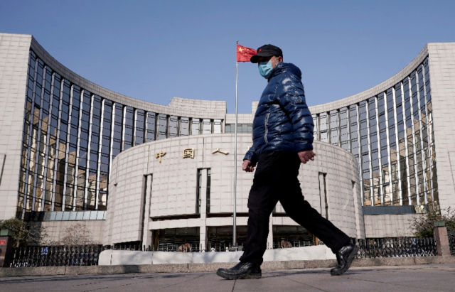 마스크를 쓴 한 남성이 중국 인민은행 앞을 걸어가고 있다. /로이터연합뉴스