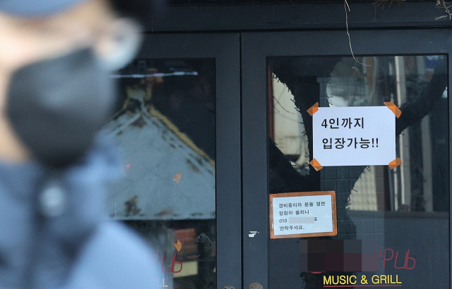 지난 1월 17일 서울 마포구 홍대거리의 한 식당에 '4인까지 입장 가능'이라는 문구가 부착돼 있다./연합뉴스