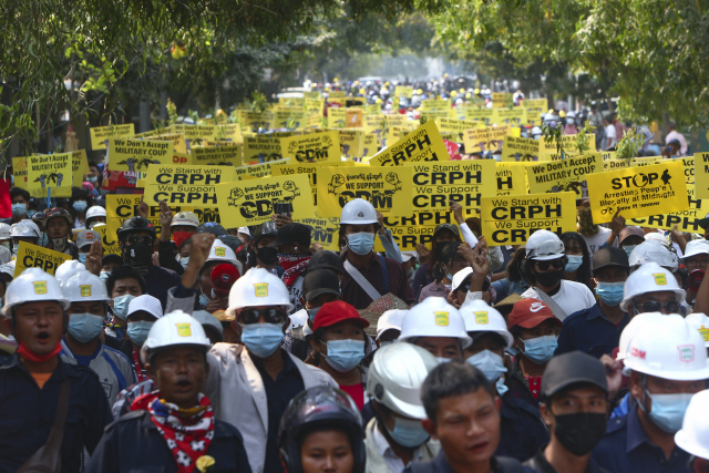 미얀마의 지방도시 만달레이에서 6일 반군부 시위대가 헬멧과 마스크를 착용하고 거리를 행진하고 있다./만달레이 AP=연합뉴스