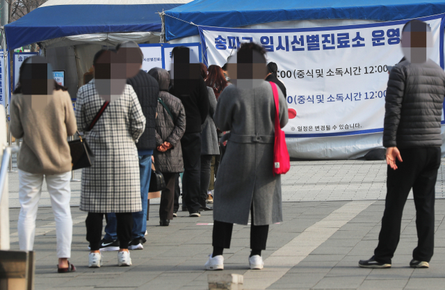 15일 오전 서울 송파구 올림픽공원 평화의문 광장에 마련된 임시선별진료소에서 시민들이 검사를 받기 위해 줄을 서고 있다. /연합뉴스