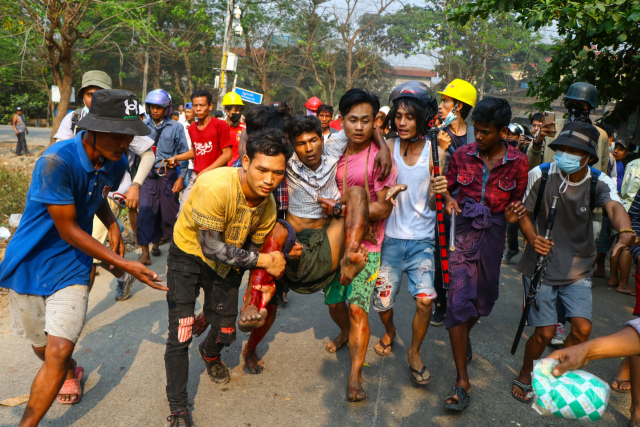 지난 14일(현지시간) 미얀마 최대 도시 양곤의 흘라잉타야 지역에서 쿠데타 반대 시위 도중 부상한 주민이 동료 시위대원들에 의해 안전한 장소로 옮겨지고 있다./AFP연합뉴스