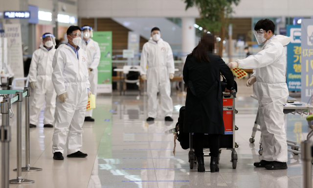 지난 15일 오후 인천국제공항 제2터미널에서 해외 입국자들이 검역지원단의 안내를 받고 있다./연합뉴스