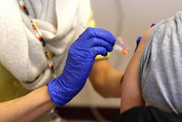 미국 시애틀의 한 공립학교 교원에게 한 의료진이 15일(현지시간) 코로나19 백신을 주사하고 있다./AFP연합뉴스