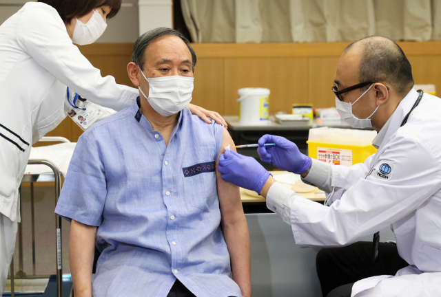 다음달 미국을 방문하는 스가 요시히데(가운데) 일본 총리가 16일 도쿄 국립국제의료연구센터에서 화이자의 코로나19 백신을 공개 접종하고 있다./로이터연합뉴스