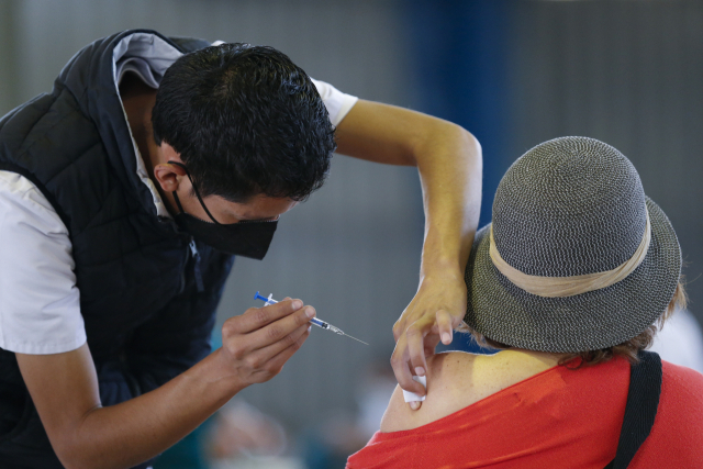 멕시코 의료인이 수도 멕시코시티에서 한 여성에게 러시아가 개발한 신종 코로나바이러스 감염증(코로나19) 백신 ‘스푸트니크 V’를 접종하고 있다. /AP연합뉴스