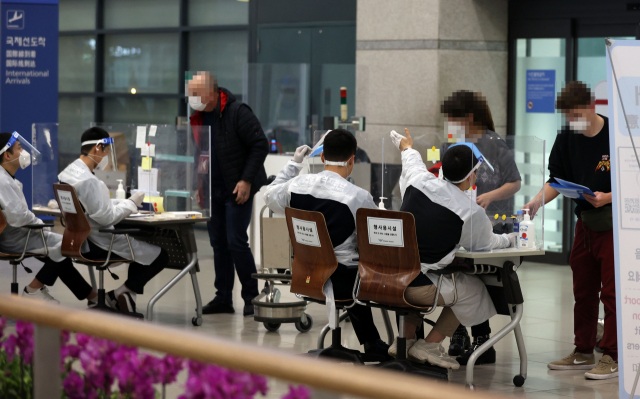 지난 15일 오후 인천국제공항 제1터미널에서 해외 입국자들이 검역지원단의 안내를 받고 있다. /연합뉴스