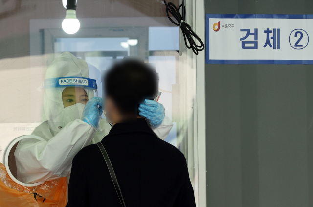 17일 서울역 광장에 마련된 중구 임시선별검사소에서 한 시민이 신종 코로나바이러스 감염증(코로나19) 검사를 받고 있다./연합뉴스