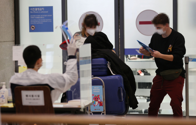 15일 오후 인천국제공항 제1터미널에서 해외 입국자들이 검역지원단의 안내를 받고 있다. /연합뉴스