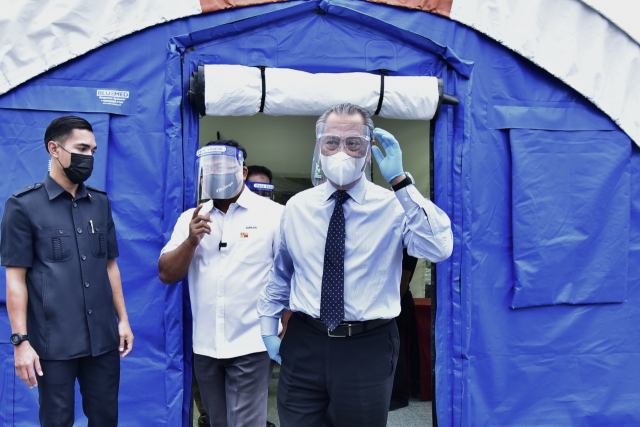 무히딘 야신(오른쪽) 말레이시아 총리가 지난 19일(현지시간) 수도 쿠알라룸푸르에 설치된 저위험 신종 코로나바이러스 감염증(코로나19) 환자를 위한 격리·치료 센터를 방문하고 있다. /연합뉴스