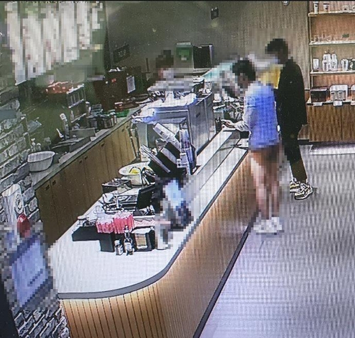 지난 18일 부산 수영구 한 카페에서 속옷 차림으로 커피를 주문하는 한 남성의 모습. /연합뉴스=부산 경찰청 제공.