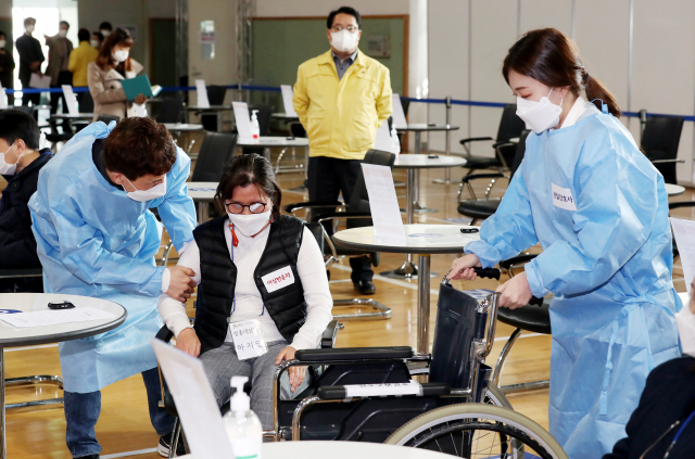 지난 19일 오전 인천시 연수구 선학체육관에 마련된 신종 코로나바이러스 감염증(코로나19) 지역예방접종센터에서 열린 모의훈련에서 센터 관계자들이 백신 이상반응을 보이는 접종자 발생 상황에 대처하는 훈련을 하고 있다./연합뉴스