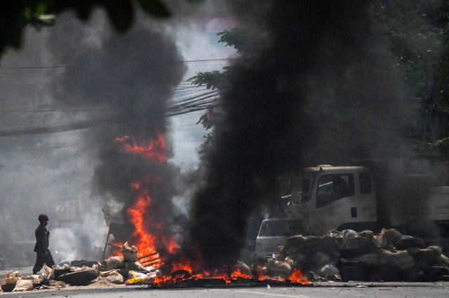 19일(현지시간) 미얀마 양곤에서 군인들이 군부 쿠데타 항의 시위대가 설치한 바리케이드를 불태우고 있다. /사진제공=연합뉴스