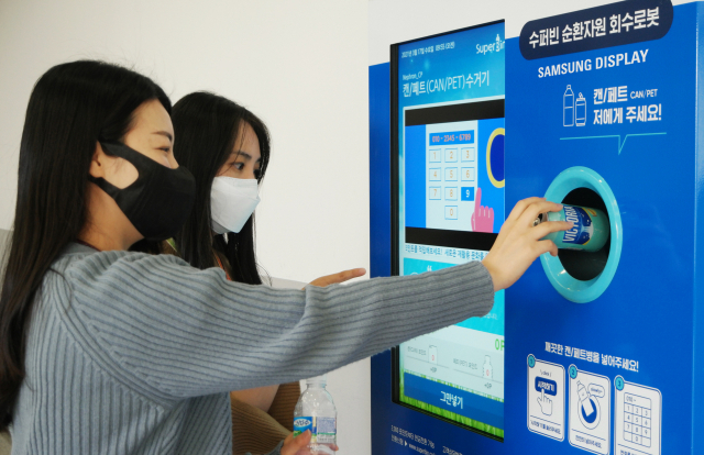 삼성디스플레이 직원들이 아산1캠퍼스에 설치된 '스마트 재활용 수거함'을 이용하고 있다. /사진제공=삼성디스플레이
