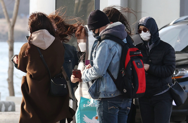 강풍이 불며 다소 쌀쌀한 날씨를 보인 21일 서울 반포한강공원에서 시민들과 외국인들이 버스를 기다리고 있다. /연합뉴스