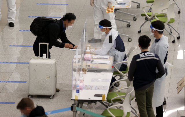 15일 오후 인천국제공항 제2터미널에서 해외 입국자들이 검역지원단의 안내를 받고 있다. /연합뉴스