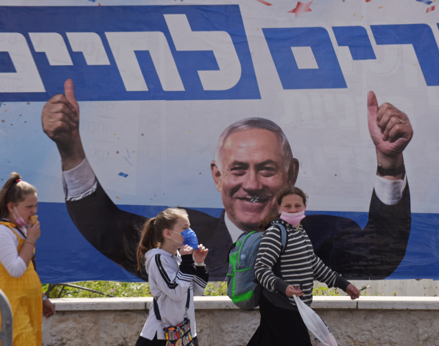 21일 이스라엘 예루살렘의 한 거리에서 소녀들이 베냐민 네타냐후 총리의 선거 포스터 앞을 지나가고 있다. /UPI연합뉴스