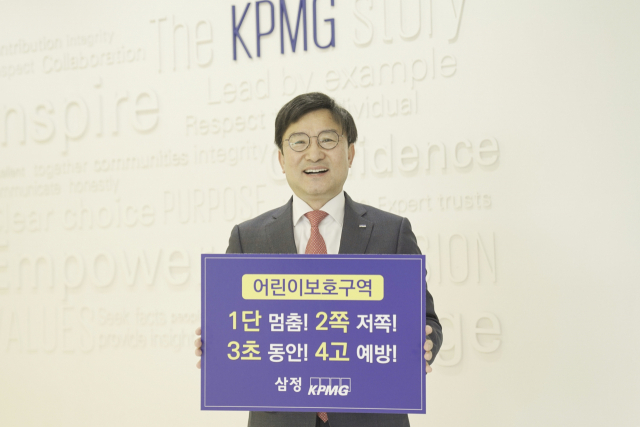 구승회 삼정KPMG 재무자문부문 대표가 22일 서울 강남구에 위치한 삼정KPMG 본사에서 ‘어린이 교통안전’ 슬로건을 들고 있다./사진제공=삼정KPMG