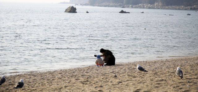 선녀바위해수욕장을 찾은 한 관광객이 어린 아이와 기념사진을 찍고 있다. 서울에서 1시간이면 도착하는 선녀바위해수욕장은 코로나19 이후 방문객이 늘어난 여행지 중 하나다.