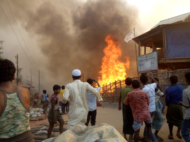 22일(현지시간) 방글라데시 콕스바자르에 있는 로힝야족 난민캠프에서 발생한 대형 화재를 사람들이 지켜보고 있다. 이 화재로 최소 5명이 사망하고 2만여명이 대피한 것으로 알려졌다. /로이터연합뉴스