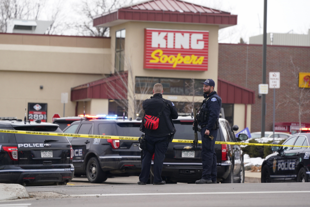 지난 22일(현지시간) 총격 사건이 벌어진 미국 콜로라도주 볼더의 '킹 수퍼스' 식료품점 건물 주변에 접근 통제선이 설치된 가운데 경찰이 경계를 서고 있다./AP연합뉴스