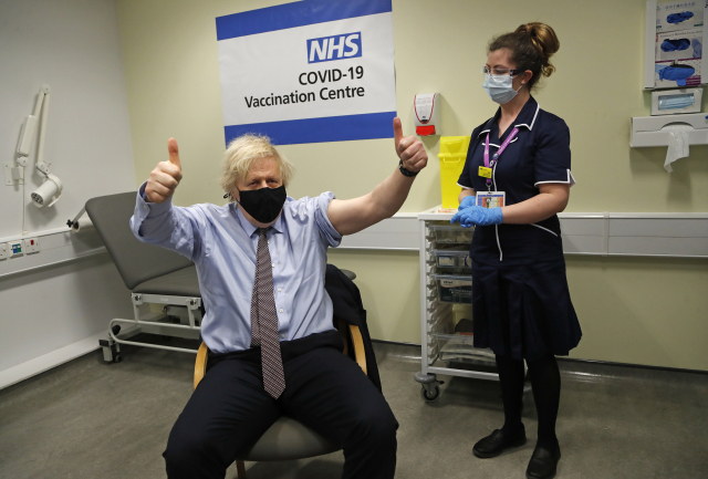 보리스 존슨 영국 총리가 지난 19일(현지시간) 런던 세인트 토머스 병원에서 아스트라제네카(AZ)의 신종 코로나바이러스 감염증(코로나19) 백신 1차 접종을 받은 뒤 두 엄지를 치켜들고 있다./AP연합뉴스