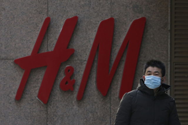 한 중국 시민이 H&M 중국 매장 앞을 지나가고 있다./AP연합뉴스