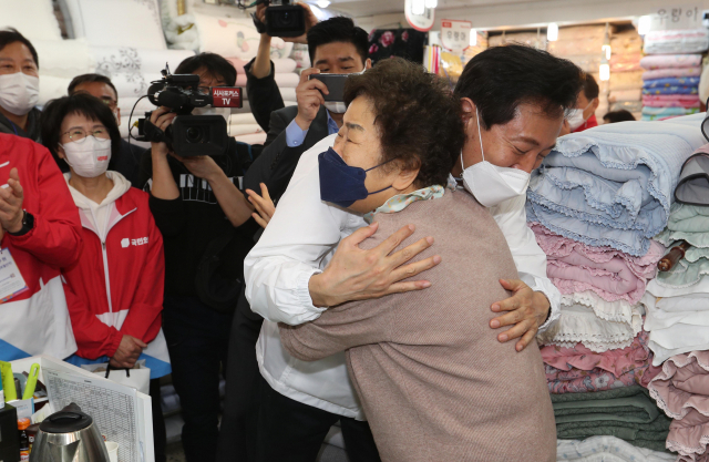 25일 남대문시장에서 선거 유세를 하던 오세훈 국민의힘 서울시장 후보가 모친이 장사하던 가게를 찾아 모친의 지인인 한 상인과 포옹을 하고 있다./권욱 기자