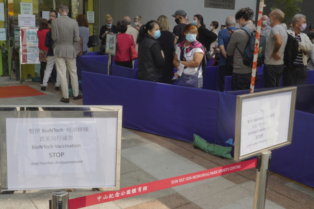 홍콩 주민들이 24일 시내의 한 화이자 신종코로나바이러스감염증(코로나19) 백신 접종 센터 주변에서 줄지어 차례를 기다리고 있다. /AP연합뉴스