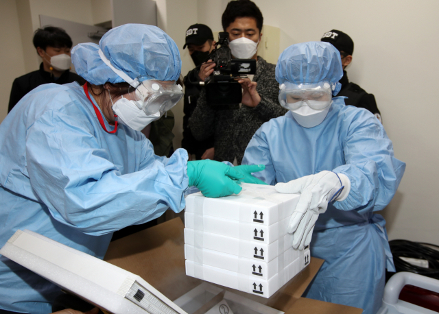 24일 오후 광주 서구 염주체육관에 마련된 예방접종센터에서 방역 관계자들이 화이자사의 신종 코로나바이러스 감염증(코로나19) 백신을 저장고에 넣기 위해 상자에서 꺼내고 있다. /연합뉴스