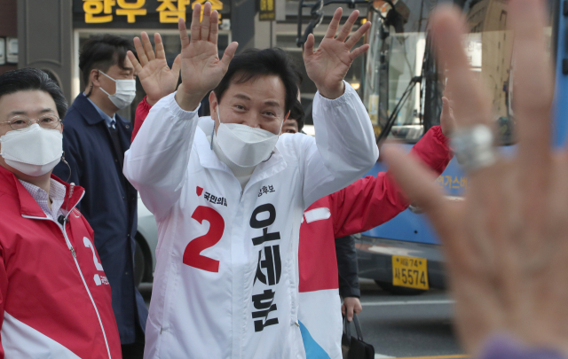 오세훈 국민의힘 서울시장 후보가 전날 서울 동대문구 경동시장 앞 유세에서 시민들을 향해 손을 흔들고 있다. /권욱 기자