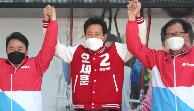 오세훈(가운데) 국민의힘 서울시장 후보가 30일 서울 영등포역 앞에서 열린 집중유세에서 지역위원장들과 함께 손들고 인사하고 있다. / 권욱 기자