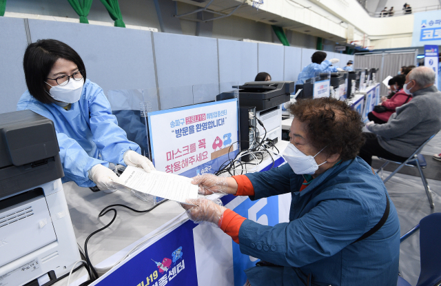1일 오전 서울 송파구 예방접종센터에서 의료진이 접종을 마친 어르신에게 백신 접종 확인서를 전달하고 있다./공동취재단