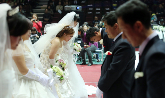 2013년 3월 5일 서울 올림픽공원 올림픽홀에서 열린 '아름다운 다문화가정 합동결혼식'에서 신랑, 신부가 인사하고 있다. /연합뉴스