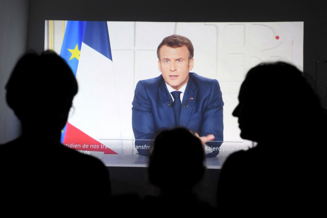 지난 31일(현지 시간) 에마뉘엘 마크롱 프랑스 대통령이 코로나19 재확산에 따른 세 번째 봉쇄령을 발표하는 모습을 사람들이 TV로 지켜보고 있다./AFP연합뉴스