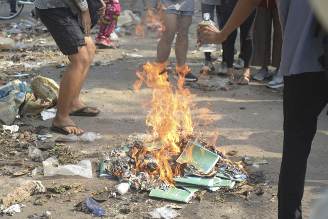 1일(현지시간) 미얀마 양곤의 한 마을에서 쿠데타 항의 시위대가 헌법 책을 불태우고 있다. /AP연합뉴스