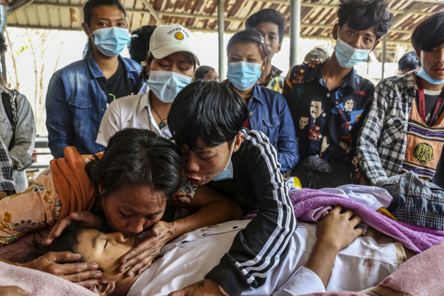 지난달 23일 미얀마 만달레이에서 군경의 총에 맞아 사망한 14세 소년 툰툰 아웅의 장례식에서 그의 가족들이 툰툰에게 작별 인사를 하고 있다./EPA연합뉴스