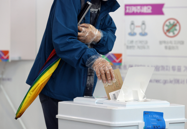 3일 오전 서울역에 마련된 남영동 사전투표소에서 한 유권자가 투표용지를 투표함에 넣고 있다./연합뉴스